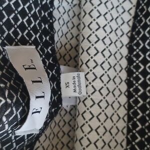 An Elle black skirt that has cream boxes on the black background. It is an XS.